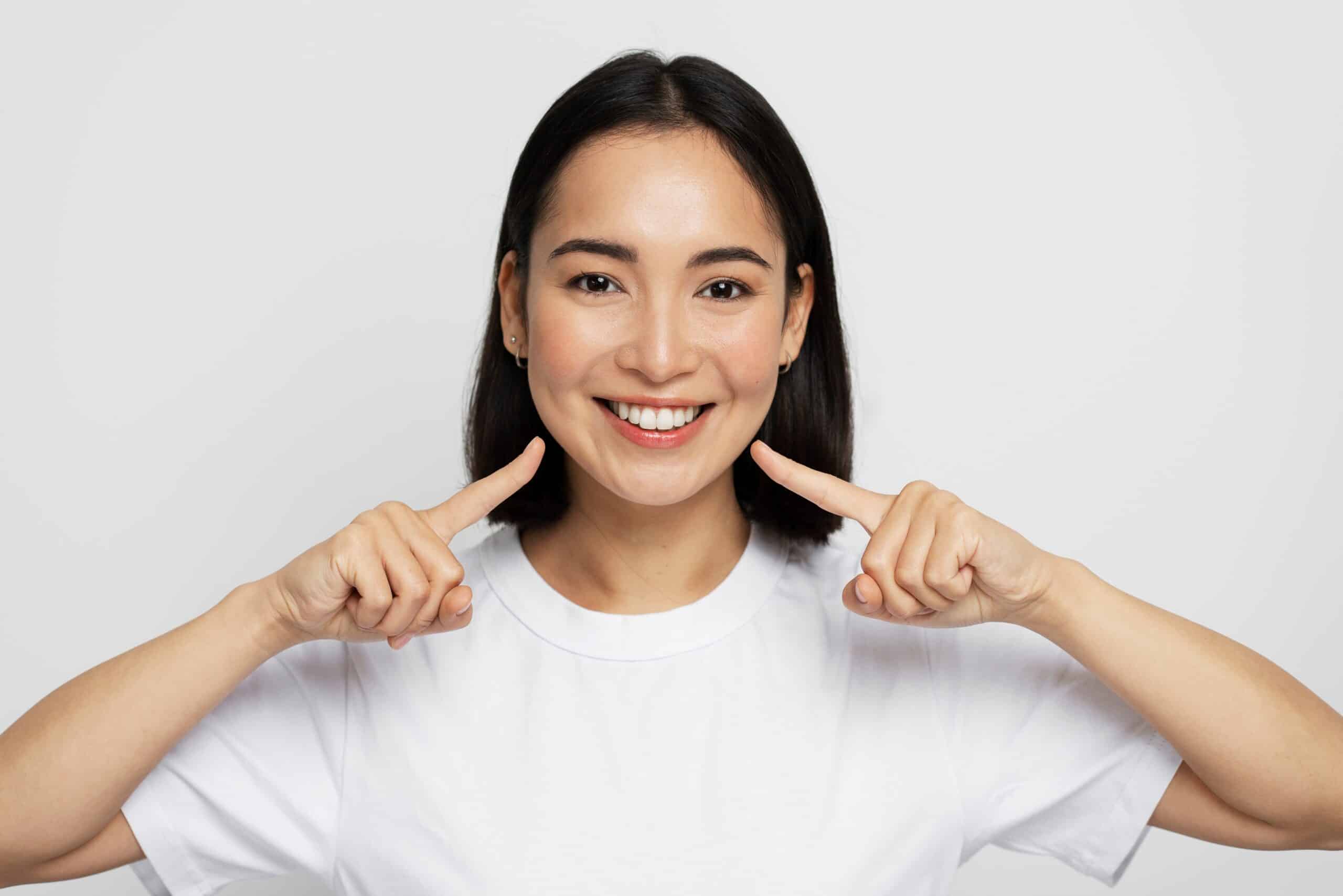 Portrait,Of,Pretty,Cheerful,Woman,Points,Index,Fingers,At,Smile